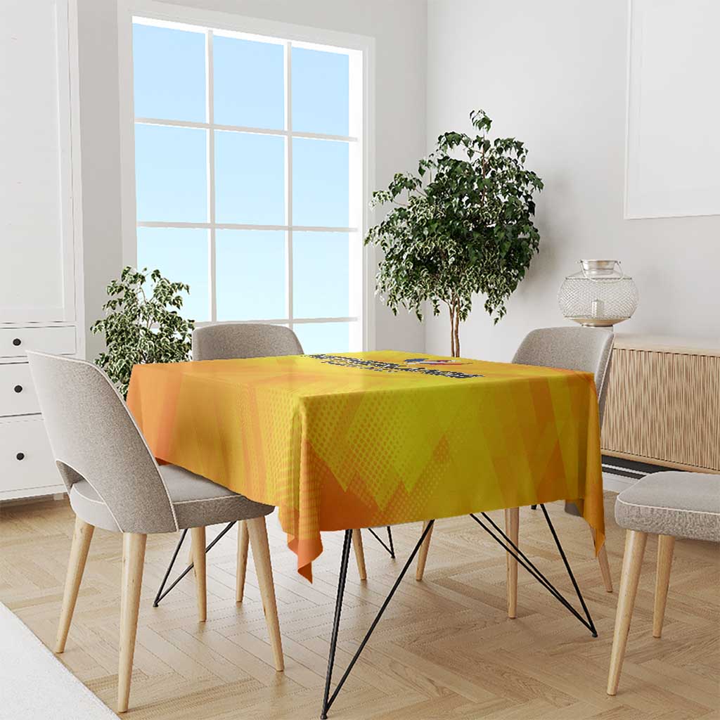 Yellow tablecloth draped over dining table with football crest design