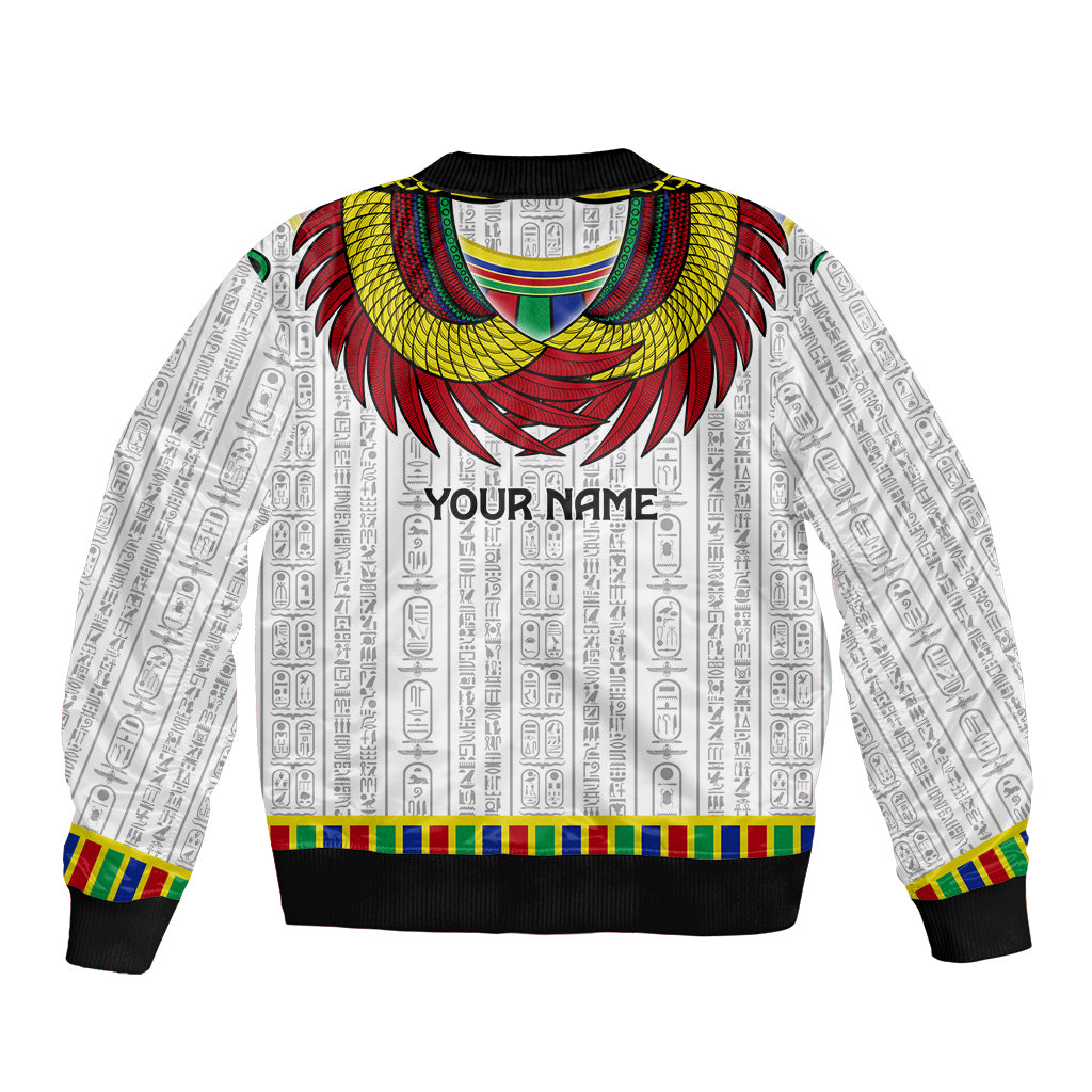 White unisex bomber jacket with Egyptian pattern, large Horus wings, and 'YOUR NAME' text