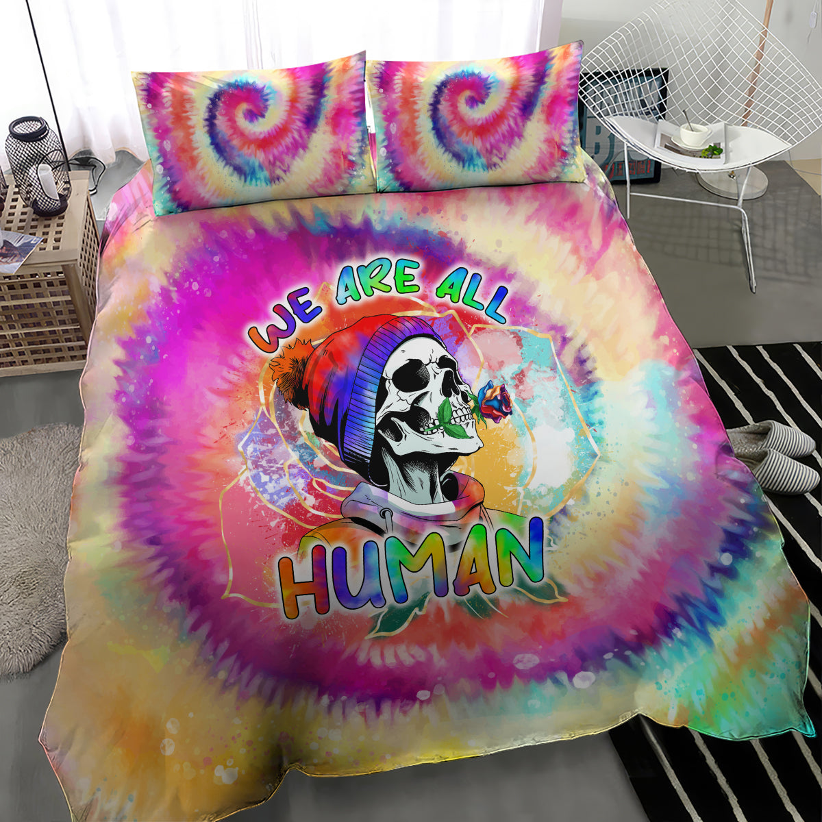 Tie-dye bedding set showing centered 'We Are All Human' skull artwork on duvet and pillows