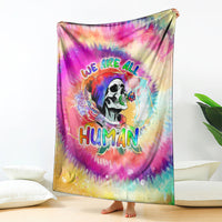 Rainbow tie-dye blanket with skull artwork and “We are all Human” lettering, draped