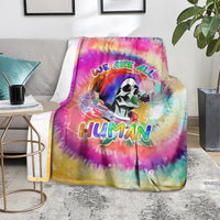 Rainbow tie-dye blanket with skull graphic and “We are all Human” text, draped on couch