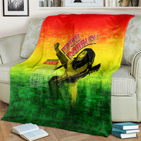 Bob Marley graphic blanket spread on couch, red-yellow-green gradient with guitar portrait