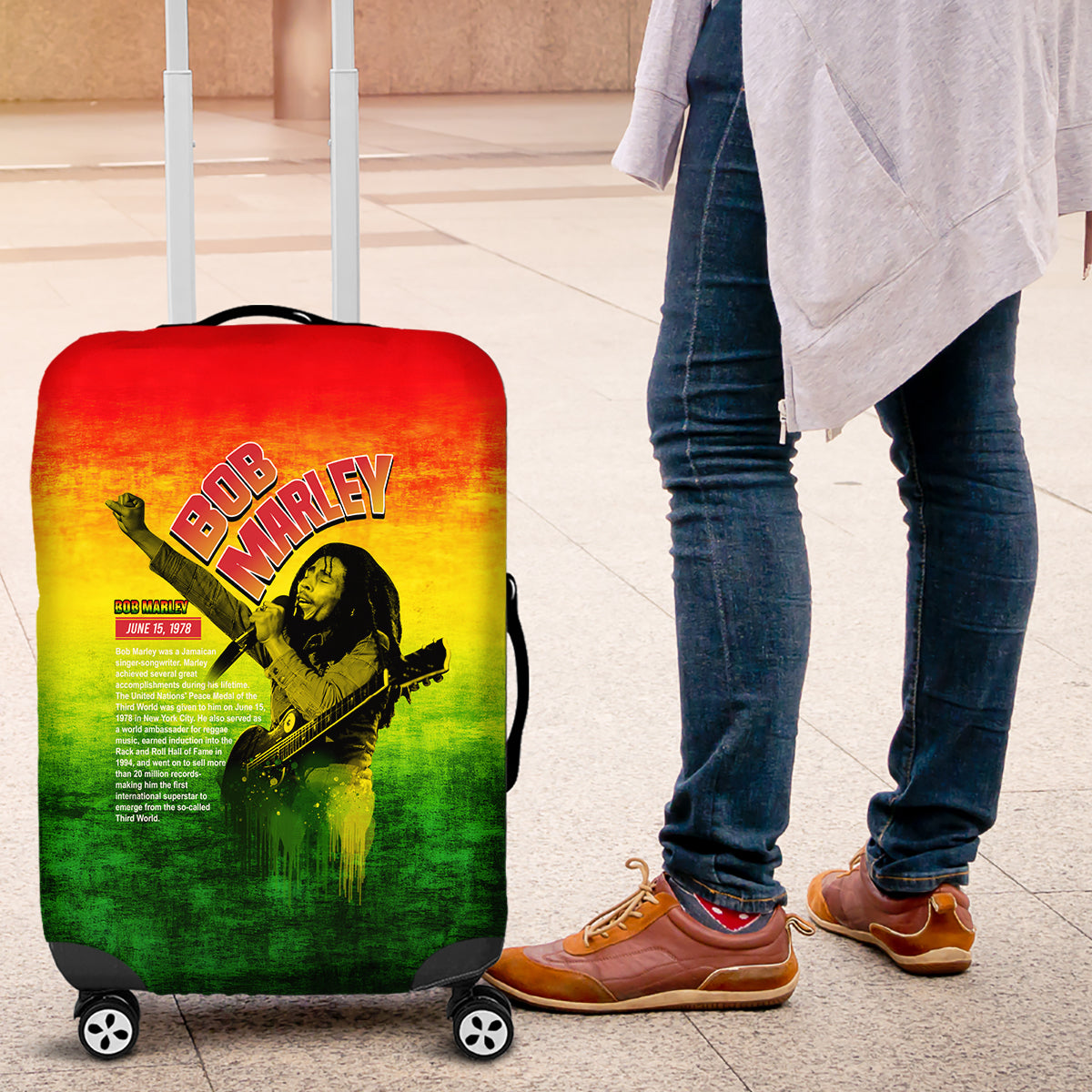 Bob Marley-themed luggage cover on rolling suitcase, red yellow green front artwork