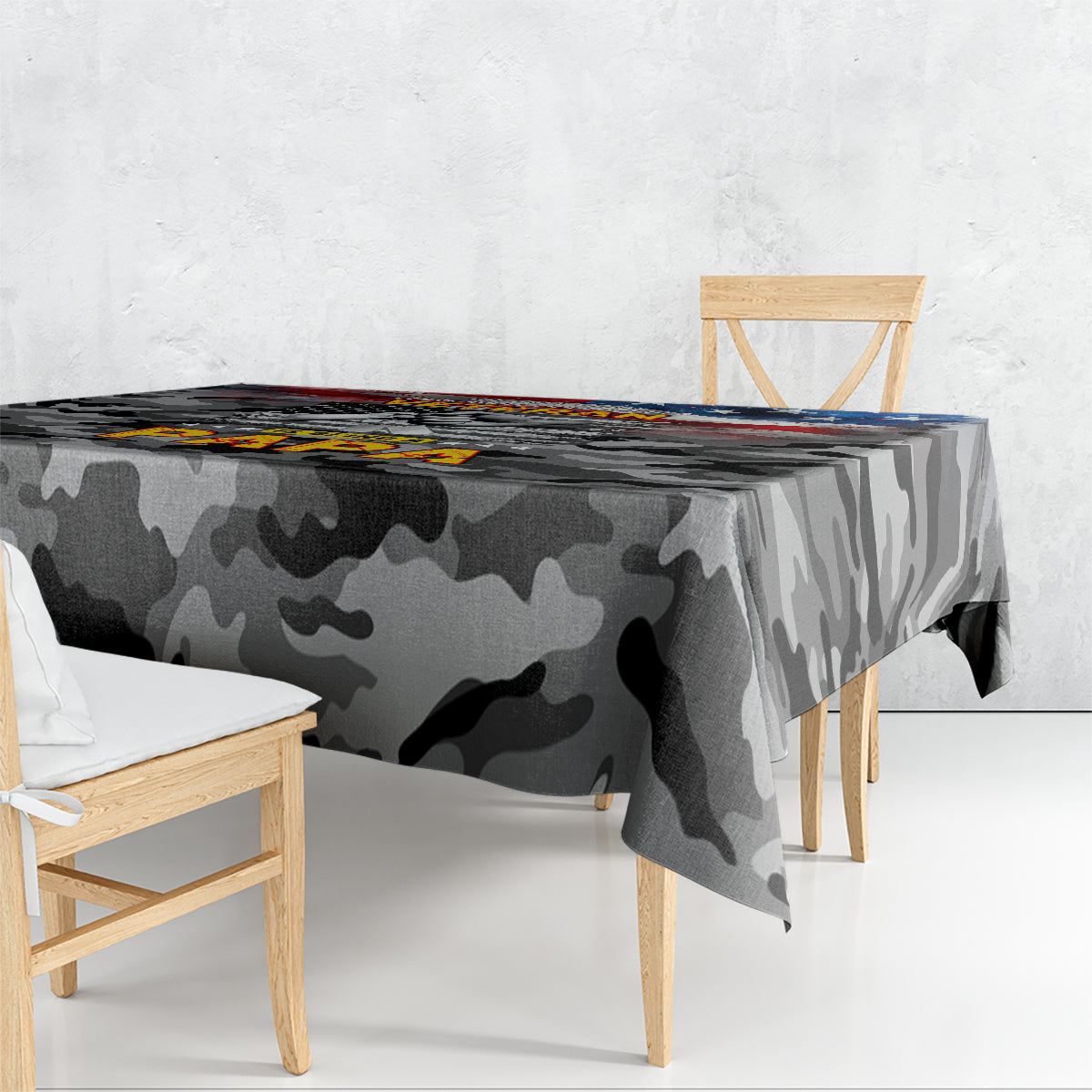 Black camouflage tablecloth draped over table with printed patriotic graphic across top