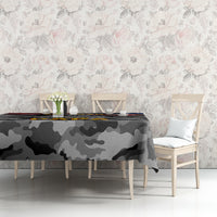 Black camouflage tablecloth on table against floral wall, patriotic graphic visible