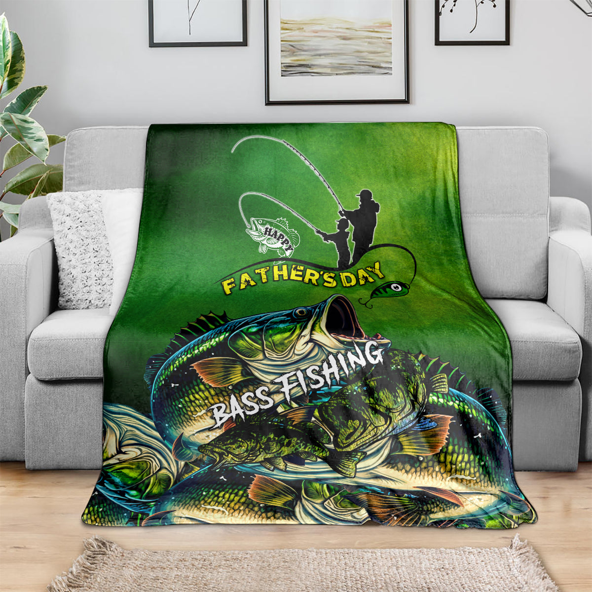 Green bass fishing Father's Day blanket on gray sofa, fisherman silhouette and bass print