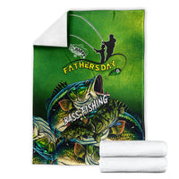 Green bass fishing Father's Day blanket folded, fisherman silhouette and bass print beside white towels