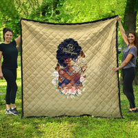 Beige quilt with diamond quilting and central religious artwork, shown spread outdoors