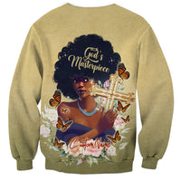Beige crewneck sweatshirt with centered graphic of woman holding cross and butterfly floral design