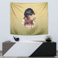 Beige tapestry mounted on wall featuring African woman with a gold cross and floral accents