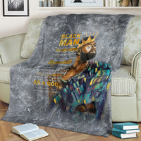 Dark gray throw blanket on couch with crowned face portrait, multicolor robe, and text