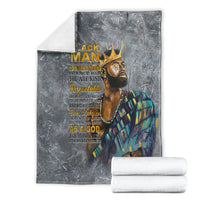 Dark gray throw blanket showing crowned face print and multicolor robe, folded edges
