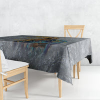 Rectangular dark blue-gray printed tablecloth draped over dining table with overhang