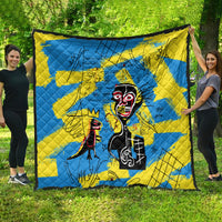 Blue and yellow quilt featuring a stylized mask face graphic in black and red details.