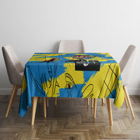 Rectangular tablecloth in blue and yellow with abstract figures on a dining set