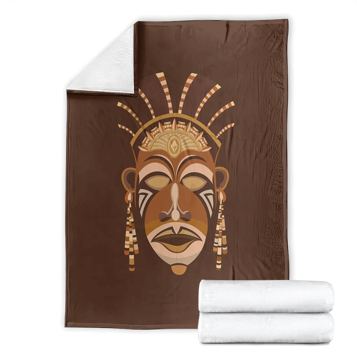 Brown tribal face print blanket with rolled white towels stacked beside it