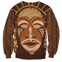 Brown crewneck sweatshirt featuring large tribal mask portrait on front