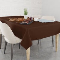 Brown tribal tablecloth with mask graphic, draped on dining table and hanging corners
