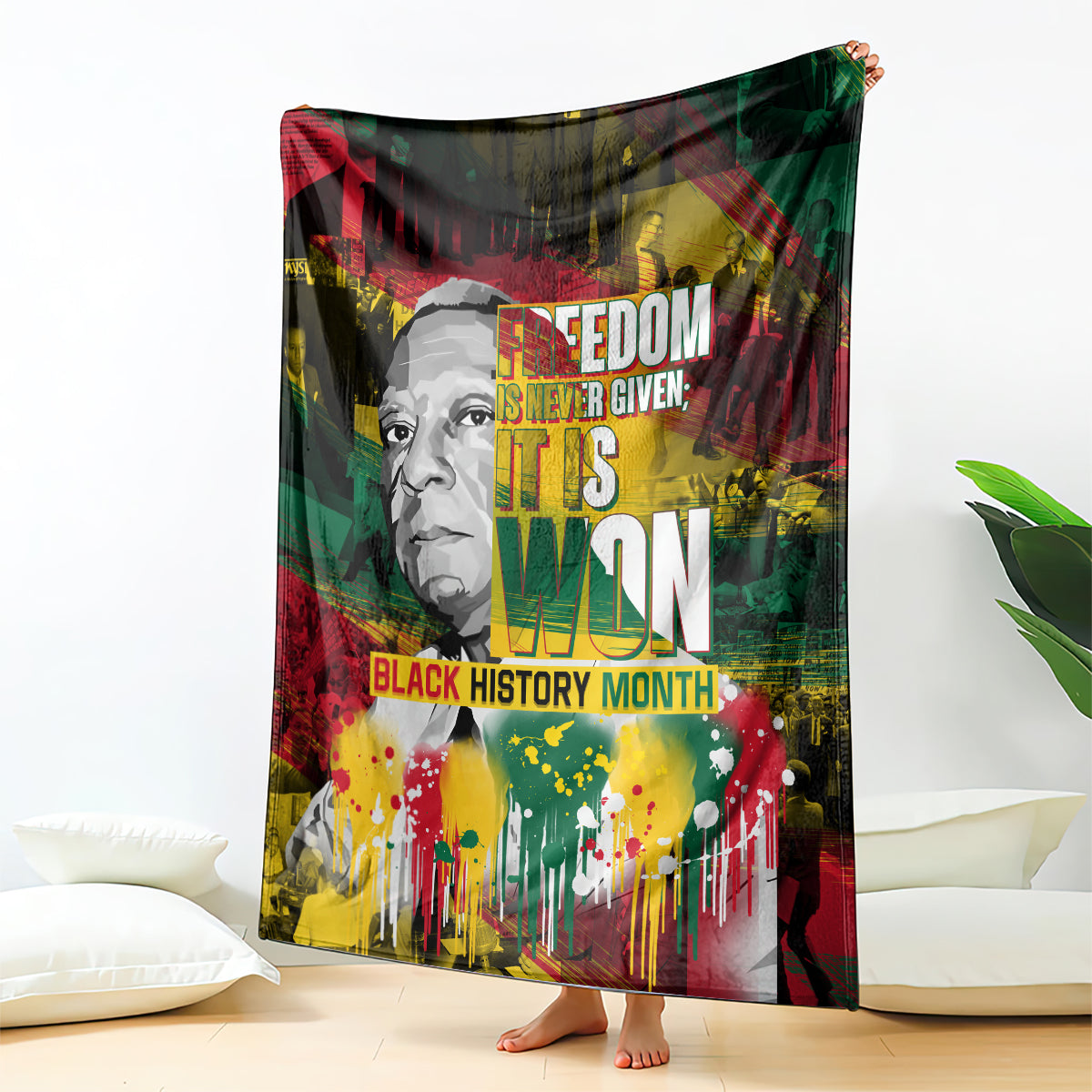 Printed black history blanket with portrait and bold text, red green yellow paint-splash design