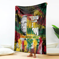 Printed black history blanket with portrait and bold text, red green yellow paint-splash design