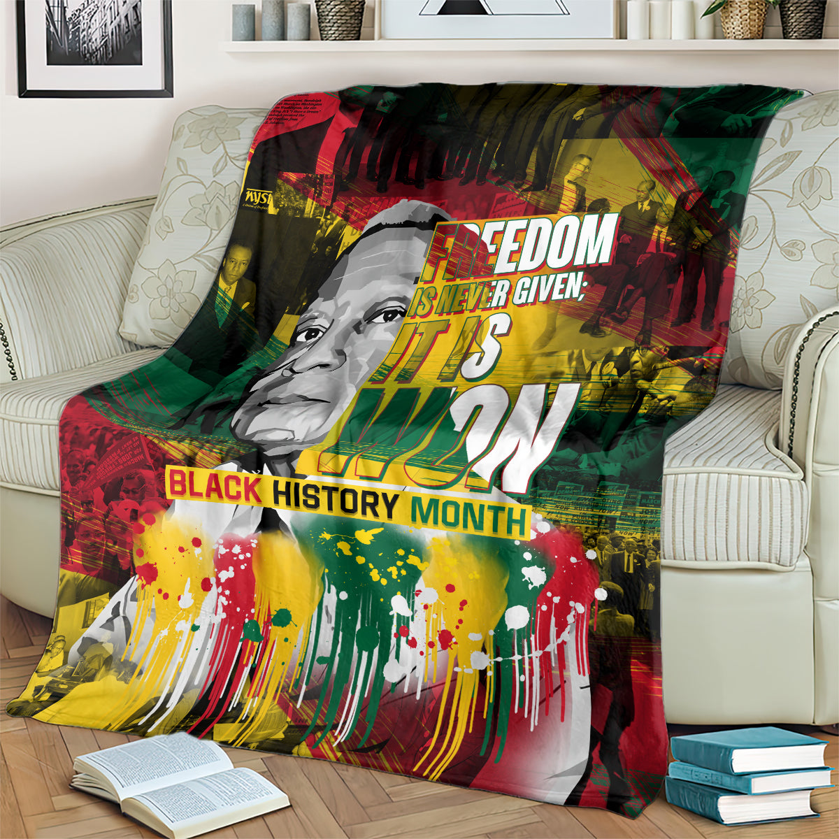 Black history portrait blanket on couch, red green yellow palette with bold text across the center
