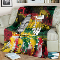 Black history portrait blanket on couch, red green yellow palette with bold text across the center