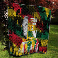 Quilt with grayscale portrait centerpiece, multicolor geometric design, and bold slogan typography