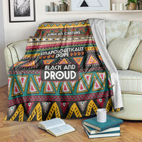 Colorful African pattern blanket with bold text and geometric triangles, draped on a sofa