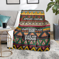 Colorful African culture blanket draped on a gray couch, featuring geometric triangle designs