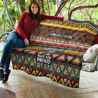 Colorful African-pattern quilt draped on a couch, with slogans “Unapologetically” and “Black and Proud.”