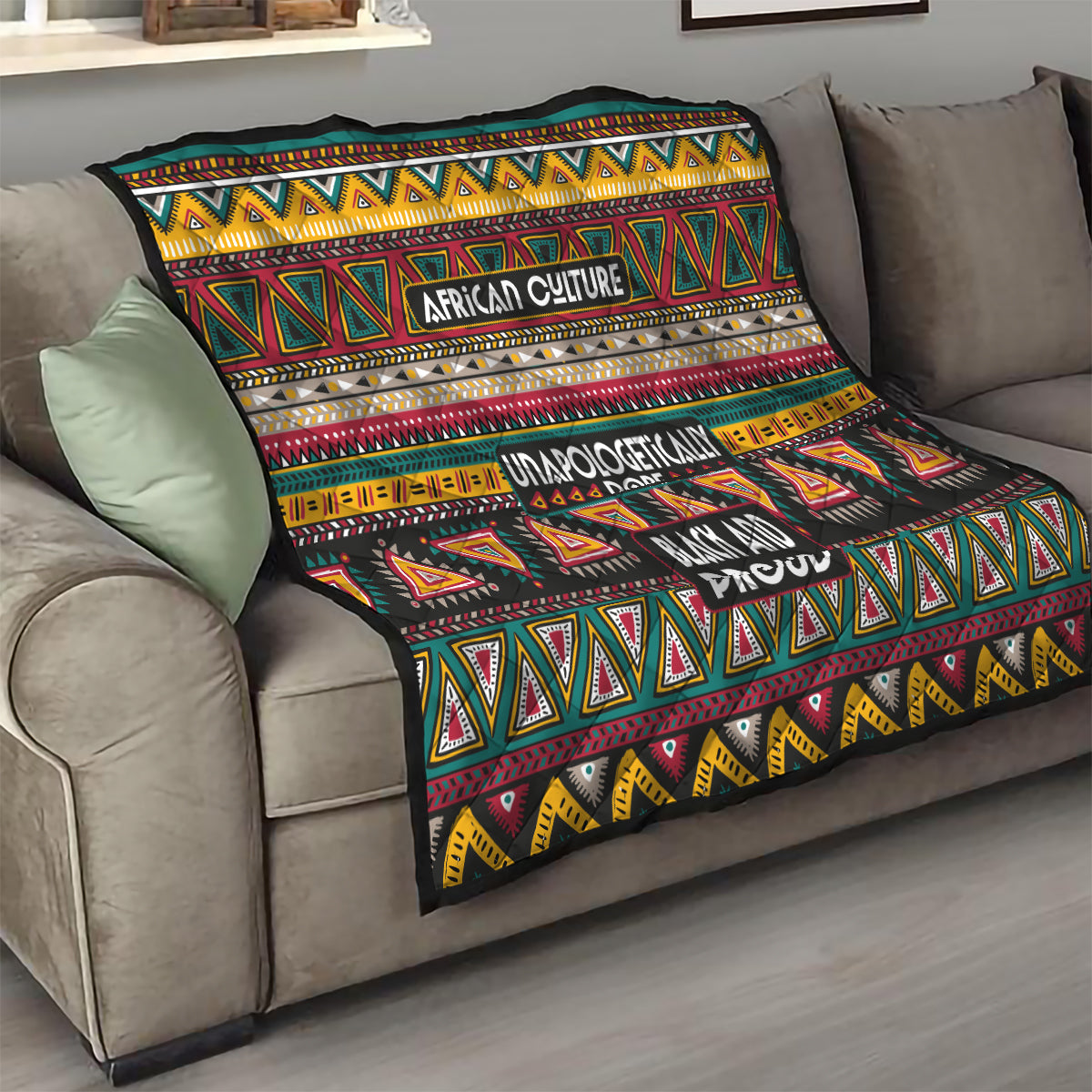 Colorful African-pattern quilt on a sofa seat, with geometric pattern and text “African Culture” and “Black and Proud.”