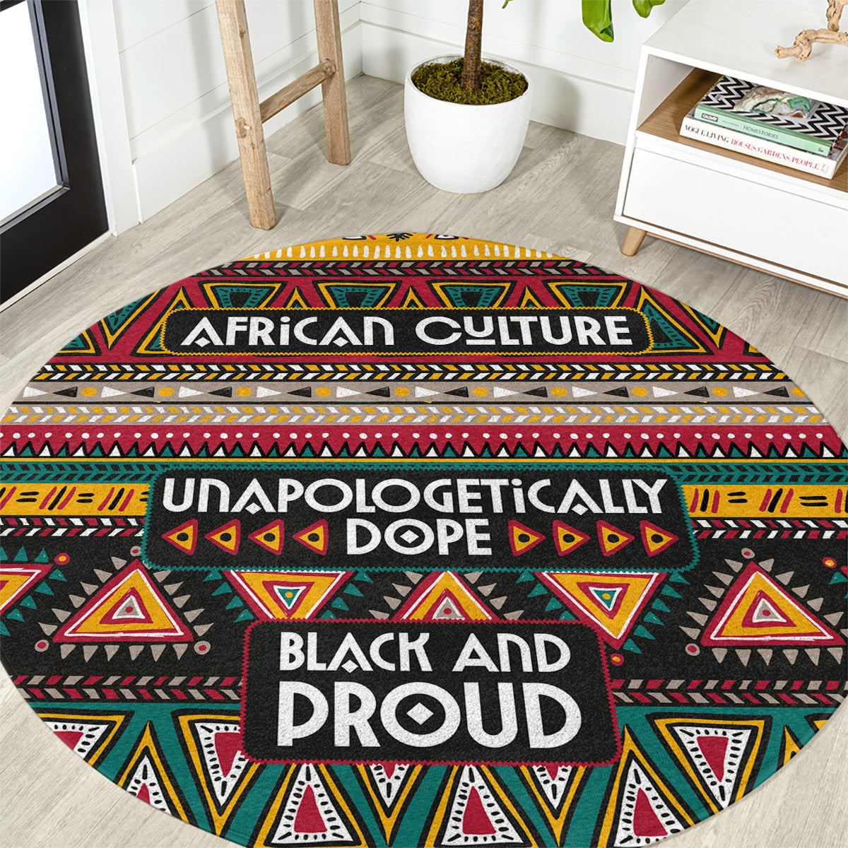 Round African-pattern carpet, black with red yellow green geometric shapes and “BLACK AND PROUD” text.