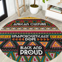 Round African-pattern carpet, black with red yellow green geometric shapes and “BLACK AND PROUD” text.