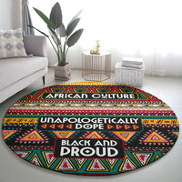 Round African-pattern carpet on floor, black base with red yellow green triangles and layered text bands.