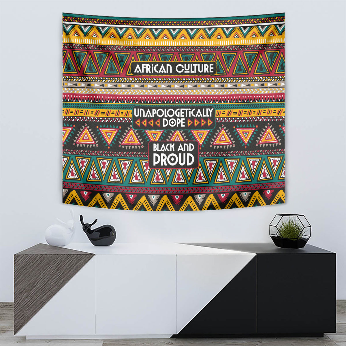 Colorful African-pattern tapestry wall hanging with centered text and multicolor triangle motifs.