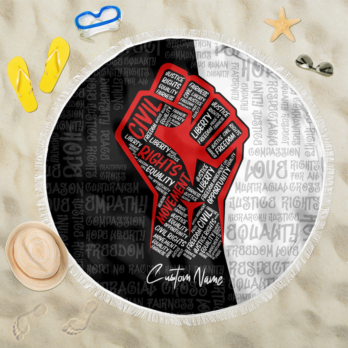 Round beach blanket with fringed edge, black base with red justice-fist word art and patterned text