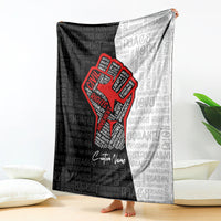 Black and gray blanket with red justice fist logo and repeating word pattern, custom name
