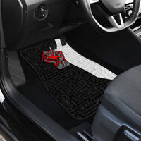 Car floor mat with black patterned surface, white section, and red justice fist design