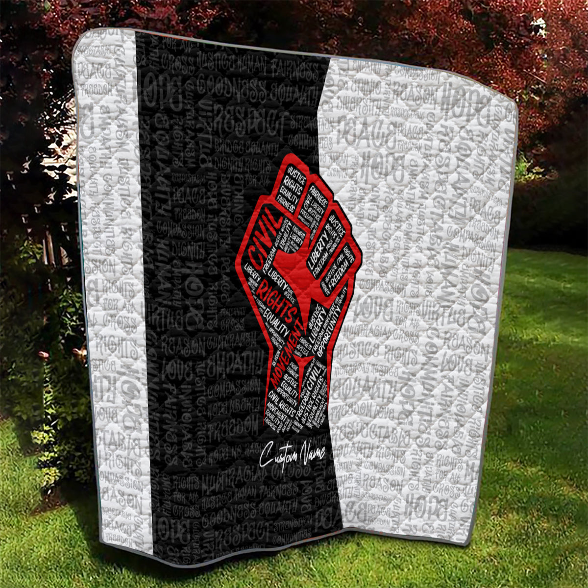 Personalized civil rights movement quilt in outdoor view, black-and-white quilt with red fist emblem