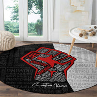 Round justice-themed carpet with bold red raised-fist graphic on black/gray text background