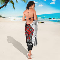 Black and light-gray sarong with red justice-fist design, worn with tie straps