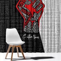 Close-up of window curtain showing red justice fist emblem over black-and-white typography