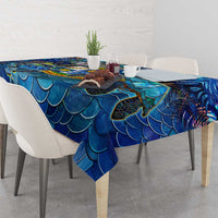 Blue scale-pattern tablecloth draped over a dining table edge
