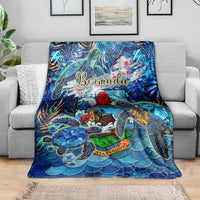 Blue sea turtle tropical throw blanket draped on a gray sofa with Bermuda lettering