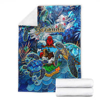 Blue sea turtle tropical throw blanket with Bermuda lettering, shown with folded white towels