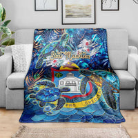 Blue sea turtle tropical blanket on sofa with Sint Maarten crest and wave scales