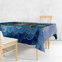 Blue sea turtle tablecloth with large wave-scale pattern, covering a wooden dining table