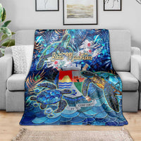 Blue sea turtle tropical blanket draped on gray couch, sea turtle and wave-scale design