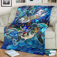 Blue sea turtle tropical print blanket on seating, showing large turtle and wave scales pattern
