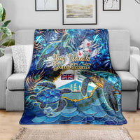Blue sea turtle tropical blanket draped over a gray sofa, scalloped scale bottom